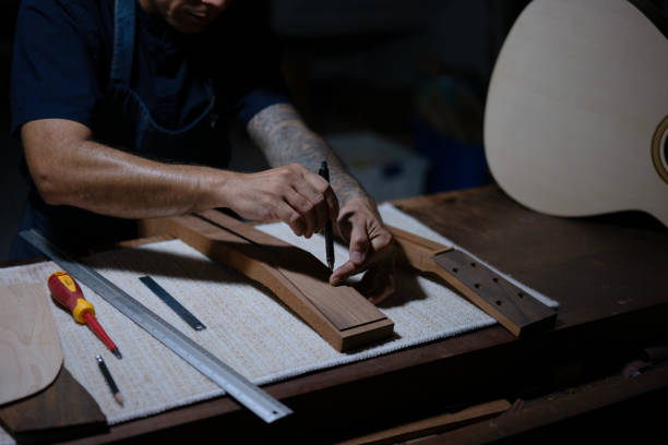 Guitar maker is working at workshop. Guitar maker is working at workshop. Small business and craft product concept. acoustic guitar tattoos stock pictures, royalty-free photos & images