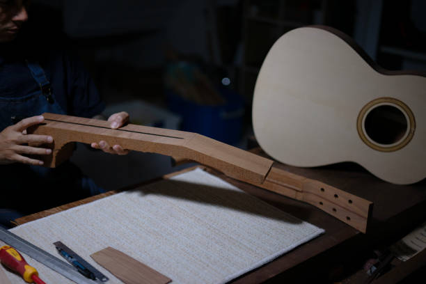Guitar maker is working at workshop. Guitar maker is working at workshop. Small business and craft product concept. acoustic guitar tattoos stock pictures, royalty-free photos & images