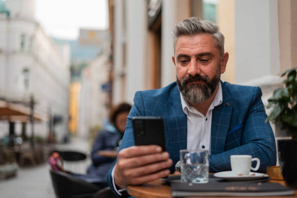 istock A mature business man typing on his phone at a restaurant cafe during a coffee break. 2190487857