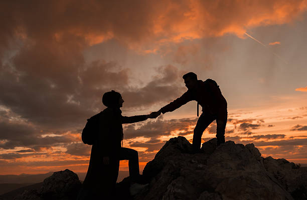 istock Hiking couple team helping each other man giving a helping hand while climbing up on the mountain rock adventure travel concept of friendship support trust teamwork success. 2190490679