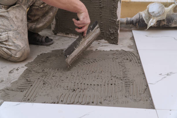 istock A construction worker applies cement for laying floor ceramic tiles with special spatula 2190491789
