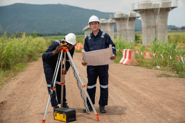 istock The survey team is using a theodolite and road construction plans to take measurements. Civil engineers are working with surveying tools to collect data for the construction project. 2190492000