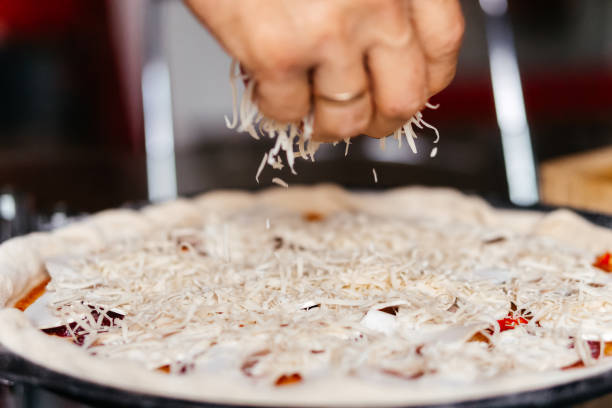 making pizza cooking at home spreading grated cheese. High quality photo