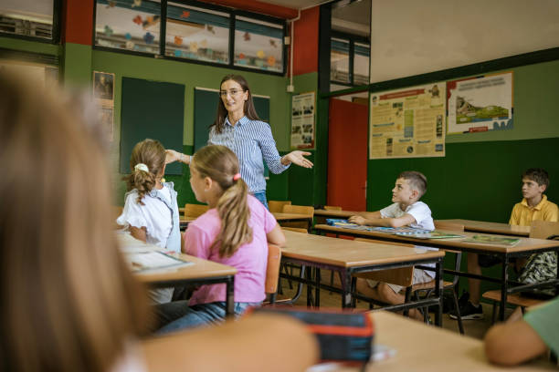 istock Teacher engaging with students in a vibrant classroom during a lesson on a sunny afternoon 2190497038