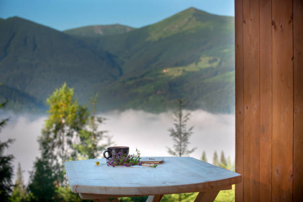 istock a cup of tea and a notepad for notes on a table with a pitchfork on a mountain summer landscape. Outdoor recreation. 2190497051