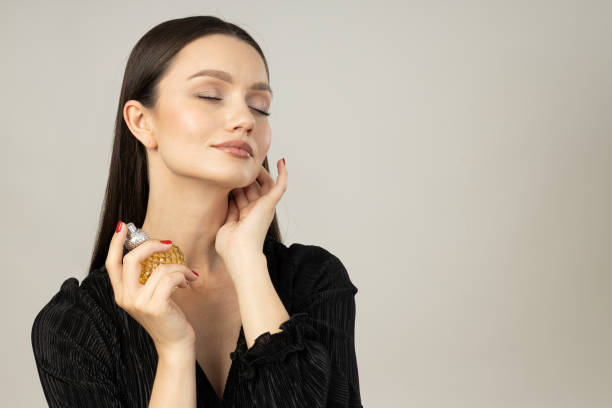 istock Young woman applying perfume on white background, space for text 2190499730