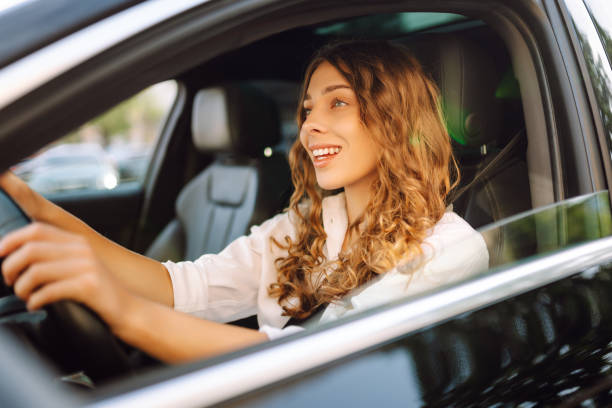 istock Young woman driving vehicle confidently, seatbelt. 2190503100