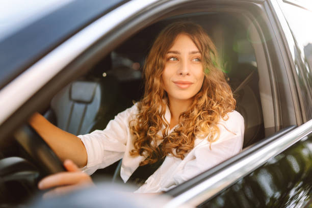 istock Young woman driving vehicle confidently, seatbelt. 2190503101
