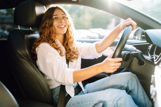 istock Young woman driving vehicle confidently, seatbelt. 2190503105