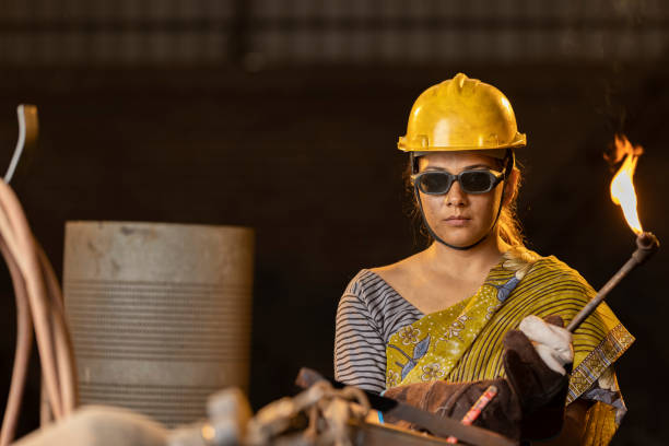 istock Female industrial worker working with blow torch in factory 2190503619