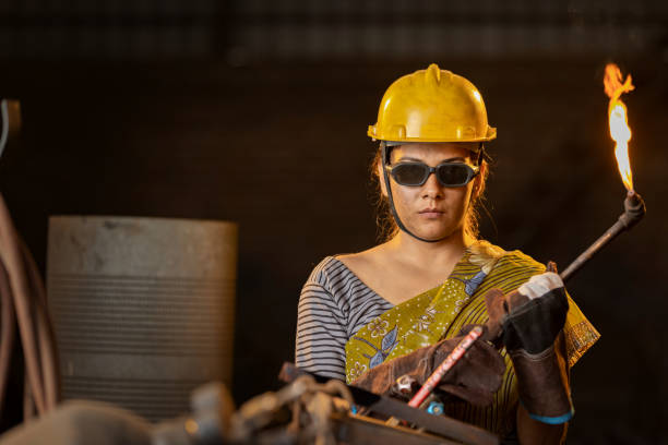 istock Female industrial worker working with blow torch in factory 2190503621