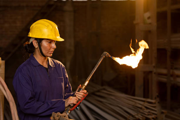 istock Female industrial worker working with blow torch in factory 2190504540