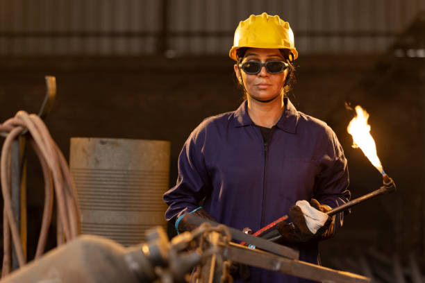 istock Female industrial worker working with blow torch in factory 2190504542