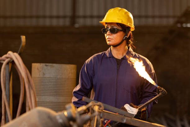 istock Female industrial worker working with blow torch in factory 2190504548