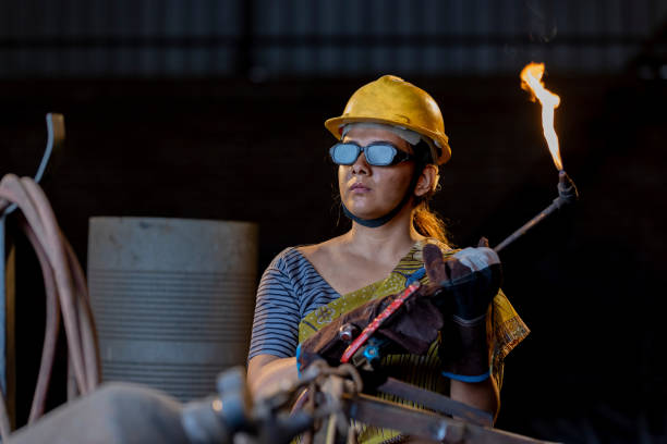 istock Female industrial worker working with blow torch in factory 2190504554