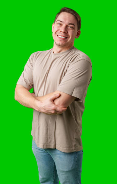 istock Smiling man in a beige shirt poses against a bright green background 2190507777