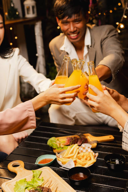 istock Group of friends clinking bottle in celebration at night. 2190508057