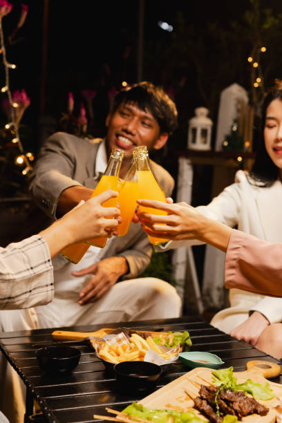 istock Group of friends clinking bottle in celebration at night. 2190508058