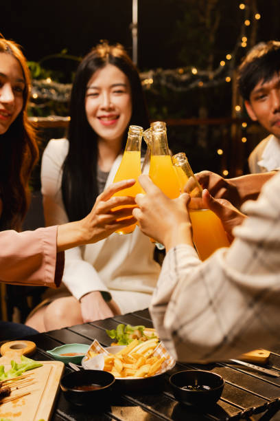 istock Group of friends clinking bottle in celebration at night. 2190508064