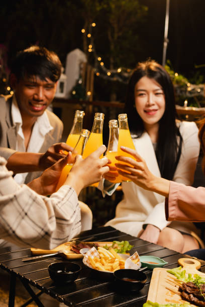 istock Group of friends clinking bottle in celebration at night. 2190508066