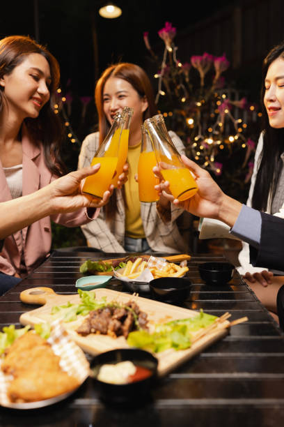 istock Group of friends clinking bottle in celebration at night. 2190508127