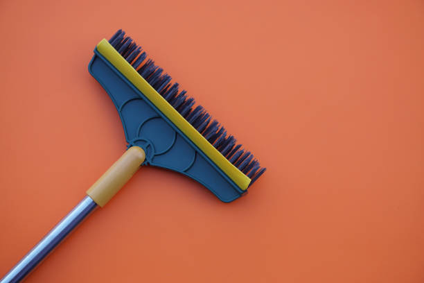 Brush for cleaning floor on orange background. Concept, tool for cleaning. use for scrub dirty on bathroom floor.