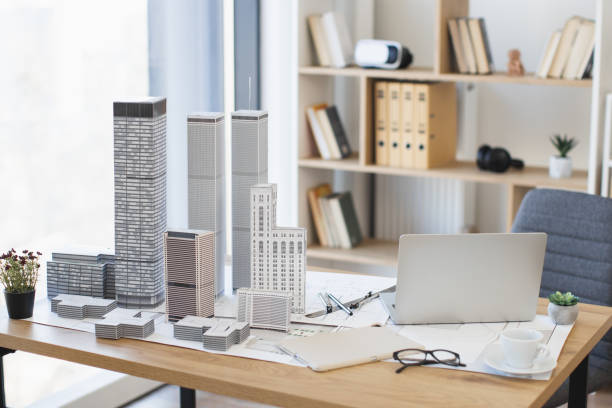 istock Modern office desk with architectural model and laptop setup 2190510132