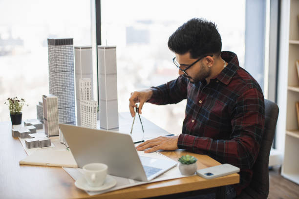 istock Indian architect measuring city model in modern office setting 2190510152