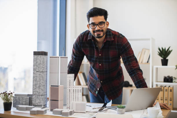 istock Indian male architect planning modern city building models 2190510242