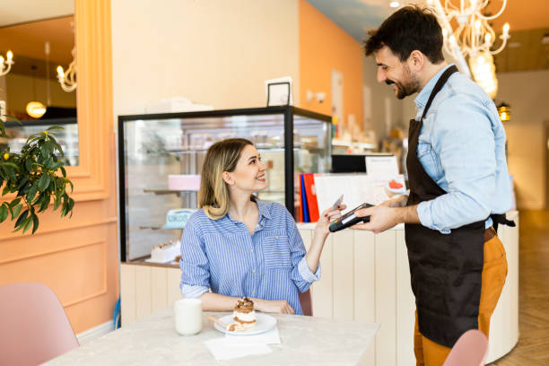 istock Shot of a young woman making a card payment using a nfc machine 2190512841