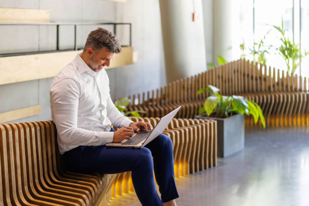 Businessman working on laptop in modern coworking space