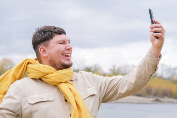 istock young caucasian man walking in the park and using smartphone 2190517185