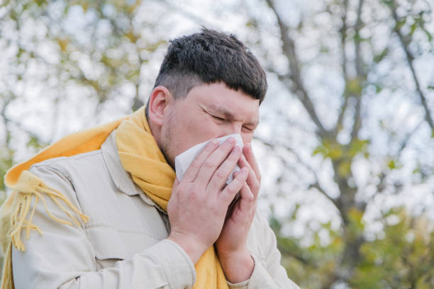 istock young man enjoying autumn days breathing fresh air using tissue to wipe nose 2190517491