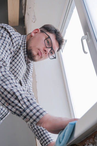 istock man cleaning a window at home. spring cleaning. 2190517971