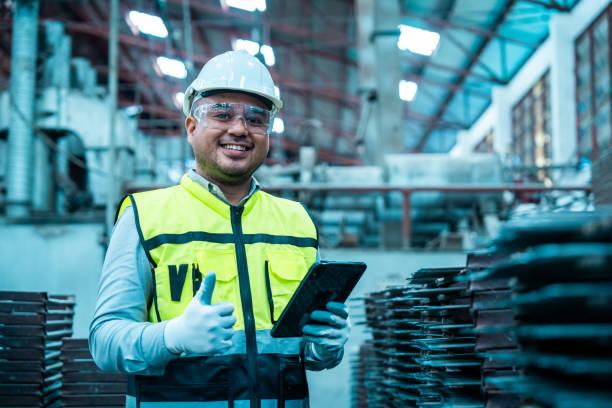 istock Confident engineer man with safety helmet standing analyzing with tablet in factory warehouse. Asian technician factory inspection and control machinery in industry factory. 2190518288