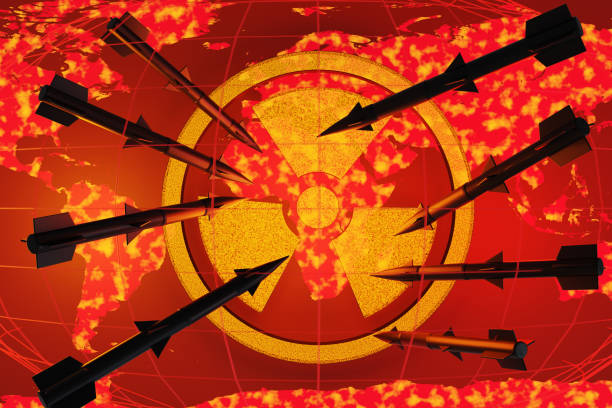 Black intercontinental ballistic missiles dropping on a nuclear radiation symbol above a red world map scattered with glowing flames. Illustration of the concept of World War 3 and nuclear weapons
