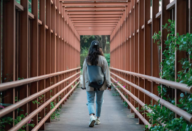 istock A woman walking on a steel structure pedestrian walkway 2190530142