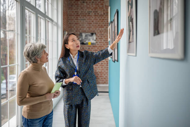 istock Curator Guiding Visitor Through Art Gallery for Educational Tour 2190532889
