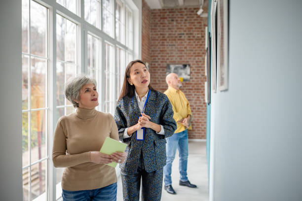 istock Visitors exploring artwork with a curator in a bright art gallery 2190532957