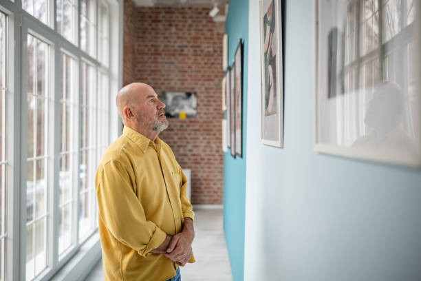istock Man observes art in a bright and modern gallery interior 2190533151
