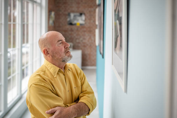istock Man admiring art pieces in a modern gallery with bright natural light 2190533198