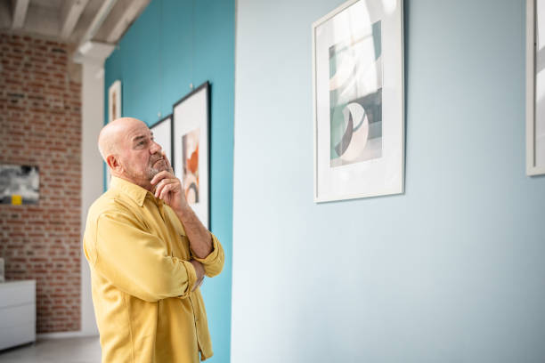 istock Man observing framed abstract artwork in a colorful modern gallery setting 2190533281