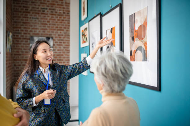 istock Art curator guiding visitors through a modern gallery exhibit 2190533844