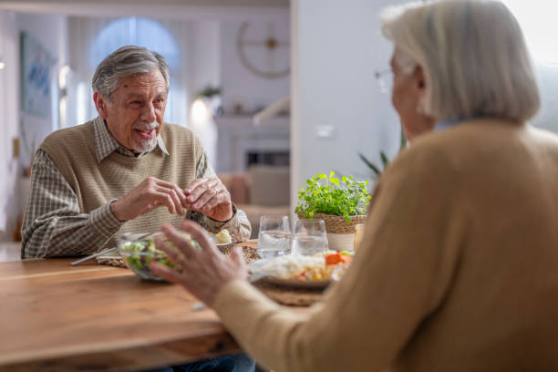 istock Senior Couple Enjoying A Warm Dinner Conversation at Home 2190533888