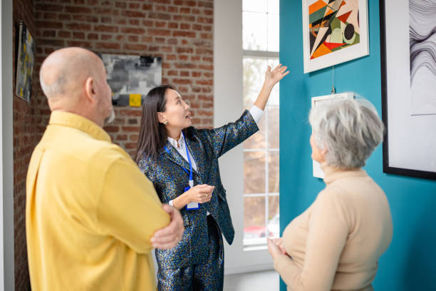 istock Curator guiding visitors through an art gallery showcasing vibrant modern artworks 2190534203