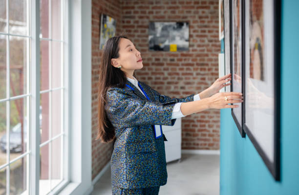 istock Art gallery curator arranging artwork on display in a modern exhibition space 2190534337