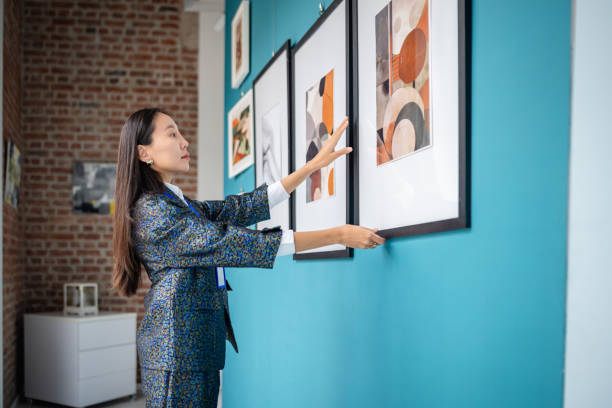 istock Curator arranging framed artwork in a modern art gallery exhibition 2190534564