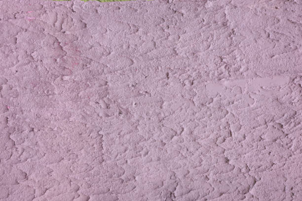 Texture of uneven, rough plaster close-up of light purple color.