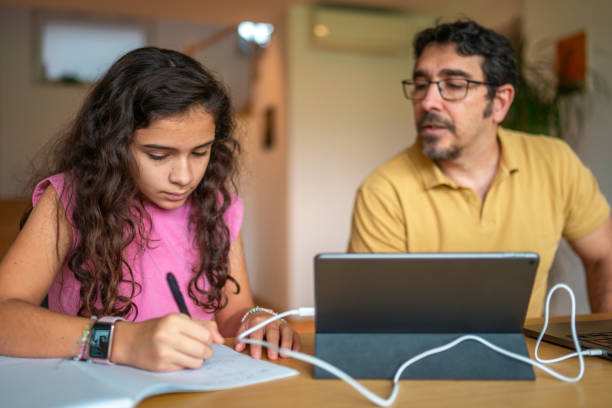 istock Mid Adult Hispanic Father Assisting Daughter with Homework 2190541055