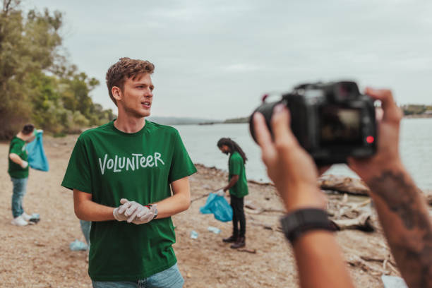 Volunteer being interviewed while cleaning the river bank